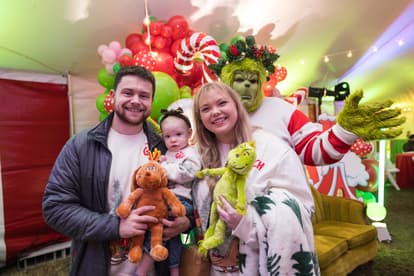 Family taking photo at Greenfield Whoville Holiday Celebration with the Grinch character 